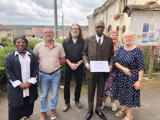 de groupe en extérieur réunissant l'auteur M. ITOUA-NDZANGA, diplôme en main, avec les membres de l'association Les Amis du Livre à Fontenoy-la-Joûte.